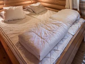 ein großes Bett mit weißen Laken und Kissen darauf in der Unterkunft Holiday Home Ruka-kitkan kuukkeli by Interhome in Säkkilänvaara