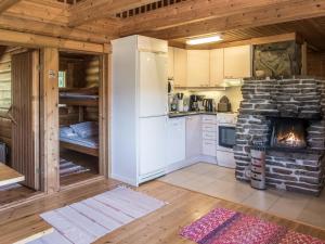eine Küche mit einem Steinkamin in einer Blockhütte in der Unterkunft Holiday Home Ruka-kitkan kuukkeli by Interhome in Säkkilänvaara