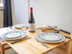 a table with a bottle of wine and plates and glasses at Apartment Vanoise-9 by Interhome in Val Thorens
