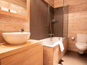 ein Badezimmer mit einem Waschbecken, einer Badewanne und einem WC in der Unterkunft Apartment Chesa Sur Val 21 by Interhome in St. Moritz