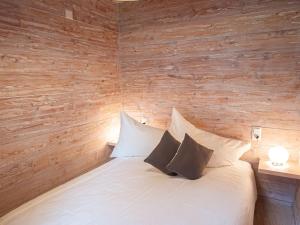 Schlafzimmer mit einem weißen Bett und Holzwänden in der Unterkunft Apartment Chesa Sur Val 21 by Interhome in St. Moritz