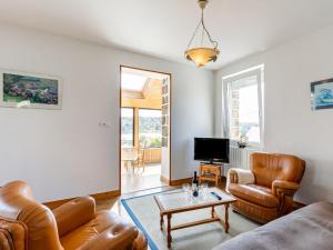 a living room with leather furniture and a tv at Holiday Home Ti an Aod by Interhome in Plougasnou