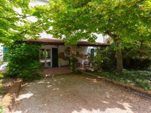 ein kleines weißes Haus mit Bäumen davor in der Unterkunft Holiday Home Fonte del Ceppo 1 by Interhome in Tortoreto Lido