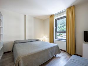 1 dormitorio con cama y ventana grande en Apartment Universo-2 by Interhome, en Pré-Saint-Didier