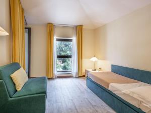 ein Schlafzimmer mit einem Bett, einem Sofa und einem Fenster in der Unterkunft Apartment Universo-4 by Interhome in Pré-Saint-Didier