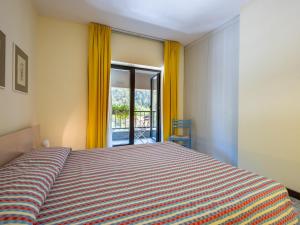 a bedroom with a bed and a window with yellow curtains at Apartment Universo-4 by Interhome in Pré-Saint-Didier