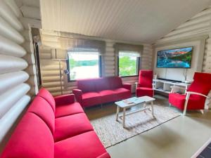 PetäjävesiにあるHoliday Home Pihlajakumpu by Interhomeのリビングルーム(赤いソファ、赤い椅子付)