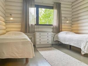 a bedroom with two beds and a window at Holiday Home Pihlajakumpu by Interhome in Petäjävesi +9 photos
