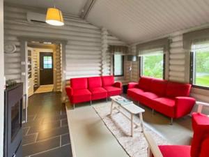 PetäjävesiにあるHoliday Home Pihlajakumpu by Interhomeのリビングルーム(赤いソファ、テーブル付)