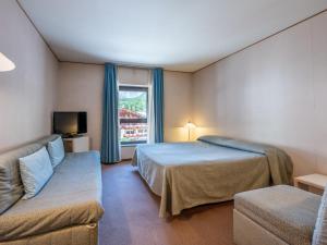 une chambre d'hôtel avec deux lits et un canapé dans l'établissement Apartment Universo-1 by Interhome, à Pré-Saint-Didier