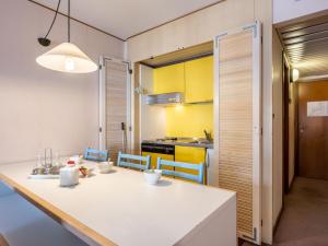 a kitchen and dining room with a white table and chairs at Apartment Universo-1 by Interhome in Pré-Saint-Didier