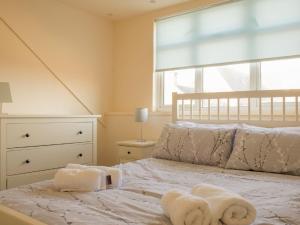 a bedroom with a bed with towels on it at Holiday Home Keepers by Interhome in Staffin +18 photos