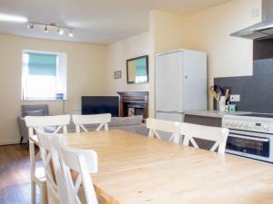 a kitchen and dining room with a wooden table and chairs at Holiday Home Keepers by Interhome in Staffin