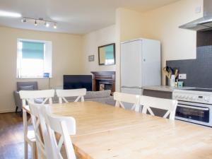 スタフィンにあるHoliday Home Keepers by Interhomeのキッチン、ダイニングルーム(木製のテーブルと椅子付)