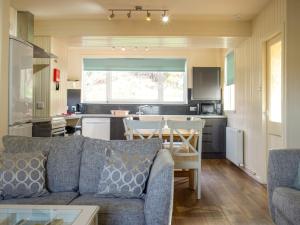 a living room with a couch and a kitchen at Holiday Home Keepers by Interhome in Staffin