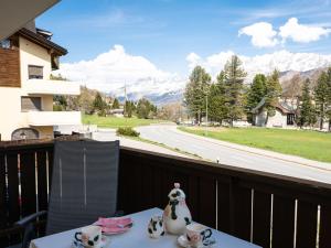 a table with a vase on a balcony with a view at Apartment Chesa Pra d`Sura 217-10 by Interhome in Maloja