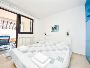 ein weißes Schlafzimmer mit einem Bett und einem Fenster in der Unterkunft Apartment Renata by Interhome in Barić Draga