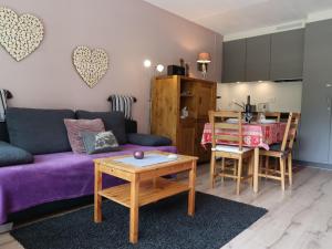 uma sala de estar com um sofá roxo e uma mesa em Studio Rosablanche D13 by Interhome em Siviez