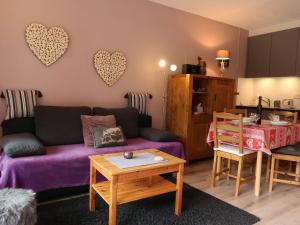 uma sala de estar com um sofá roxo e uma mesa em Studio Rosablanche D13 by Interhome em Siviez