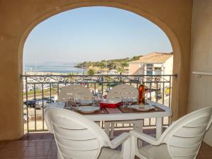 a table and chairs on a balcony with a view of the ocean at Apartment Les Rivages de Coudoulière-10 by Interhome in Six-Fours-les-Plages