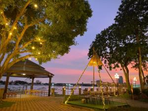 a gazebo with tables and chairs at night at Montien Riverside Hotel Bangkok in Bangkok