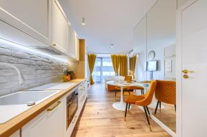 a kitchen and living room with a table and a couch at Wola Luxury Stay in Warsaw