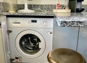 una lavatrice bianca in una cucina con bancone di Le P'tit Charmant : centre historique de Dijon a Digione