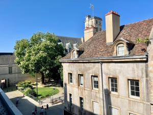 un vecchio edificio con una torre sopra di Le P'tit Charmant : centre historique de Dijon a Digione