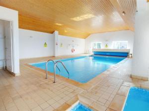 a large swimming pool with blue water in a room at Apartment Flat 11 Clifton Court by Interhome in Croyde