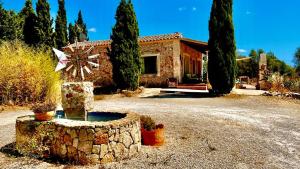 una casa con una fontana di fronte di Finca Es Velar a Santanyi