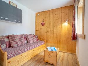 a bedroom with a bed with a wooden wall at Apartment Arcelle-22 by Interhome in Val Thorens