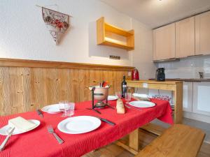 a kitchen with a table with a red table cloth at Apartment Arcelle-22 by Interhome in Val Thorens