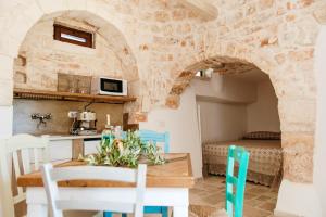 eine Küche und ein Esszimmer mit einem Tisch und Stühlen in der Unterkunft Trulli delle Sete in Locorotondo