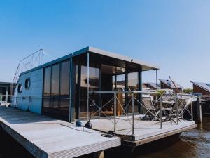 een huis op een dok aan het water bij Holiday Home De Meerparel by Interhome in Uitgeest