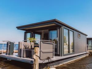 a tiny house on a dock on the water at Holiday Home De Meerparel-1 by Interhome in Uitgeest