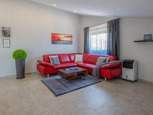 salon z czerwoną kanapą i stołem w obiekcie Holiday Home La Mer by Interhome w mieście Lovran