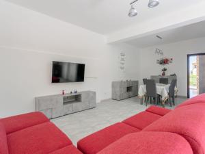 a living room with a red couch and a tv at Holiday Home Alice by Interhome in Ficarazzi +38 photos
