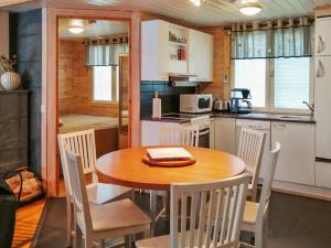 Il comprend une cuisine et une salle à manger avec une table et des chaises en bois. dans l'établissement Holiday Home Rukan pramea by Interhome, à Ruka