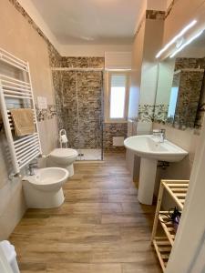 ein Badezimmer mit zwei Waschbecken, zwei WCs und einer Dusche in der Unterkunft Joya house in Taranto