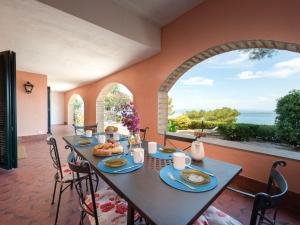 a dining room with a table and a large window at Holiday Home Sole by Interhome in Porto Santo Stefano
