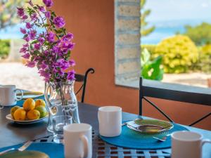 een tafel met een vaas met paarse bloemen erop bij Holiday Home Sole by Interhome in Porto Santo Stefano