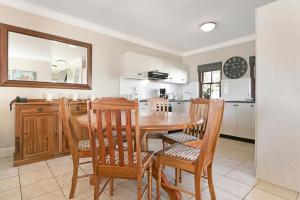 a kitchen and dining room with a wooden table and chairs at Winelands Golf Lodges 11 in Stellenbosch