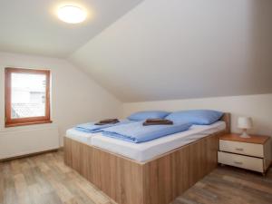 sypialnia z łóżkiem z niebieskimi prześcieradłami i oknem w obiekcie Holiday Home Dehtáře by Interhome w mieście Hluboká nad Vltavou
