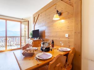 Apartment Les Alpages du Corbier-7 by Interhome في لي كوربيه: طاولة غرفة طعام خشبية مع خلاط عليها