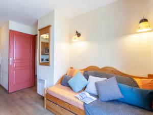 Apartment Les Alpages du Corbier-7 by Interhome في لي كوربيه: غرفة معيشة مع أريكة وباب احمر