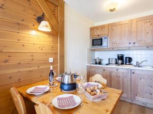 una cocina con una mesa de madera con una olla. en Apartment Les Alpages du Corbier-7 by Interhome en Le Corbier