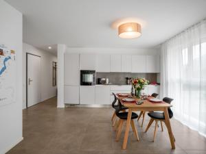 uma cozinha e sala de jantar com mesa e cadeiras em Apartment LocTowers A3-6-3 by Interhome em Locarno