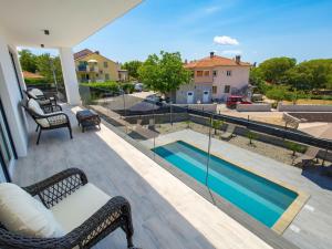 balkon z widokiem na basen w obiekcie Holiday Home Villa Palma by Interhome w mieście Pinezići