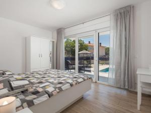 sypialnia z łóżkiem oraz balkon z basenem w obiekcie Holiday Home Villa Palma by Interhome w mieście Pinezići