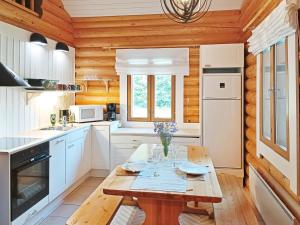 une cuisine avec des placards blancs et une table en bois dans l'établissement Holiday Home Purnutar a by Interhome, à Kolinkylä